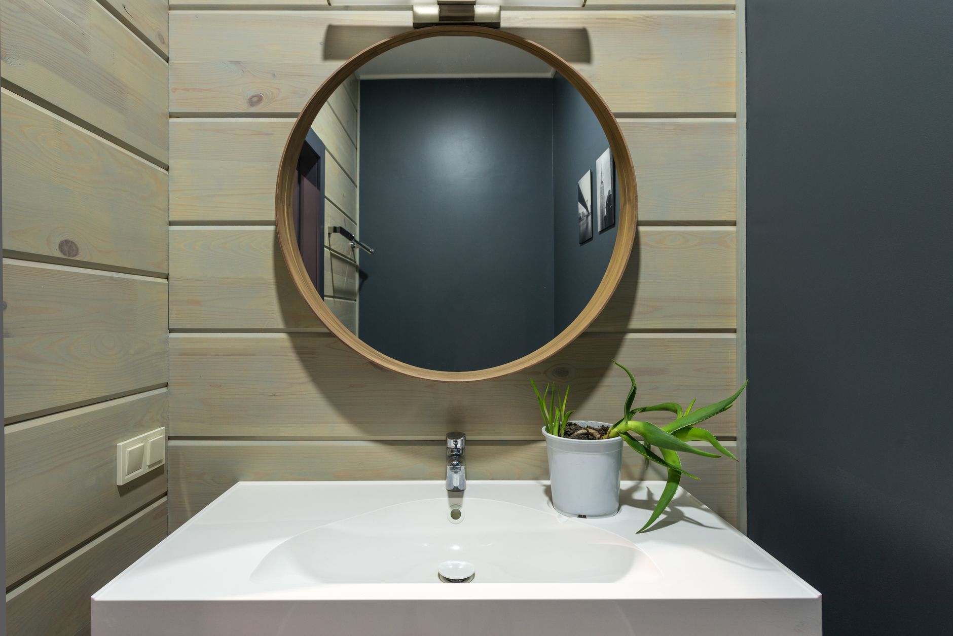 A small internal bathroom with a mirror above the sink and no window