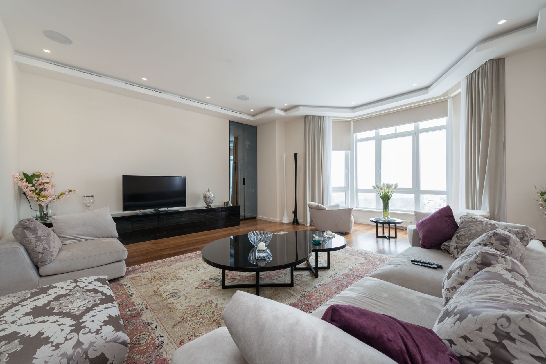 A sofa against a wall with a large rug and a low coffee table in front of it